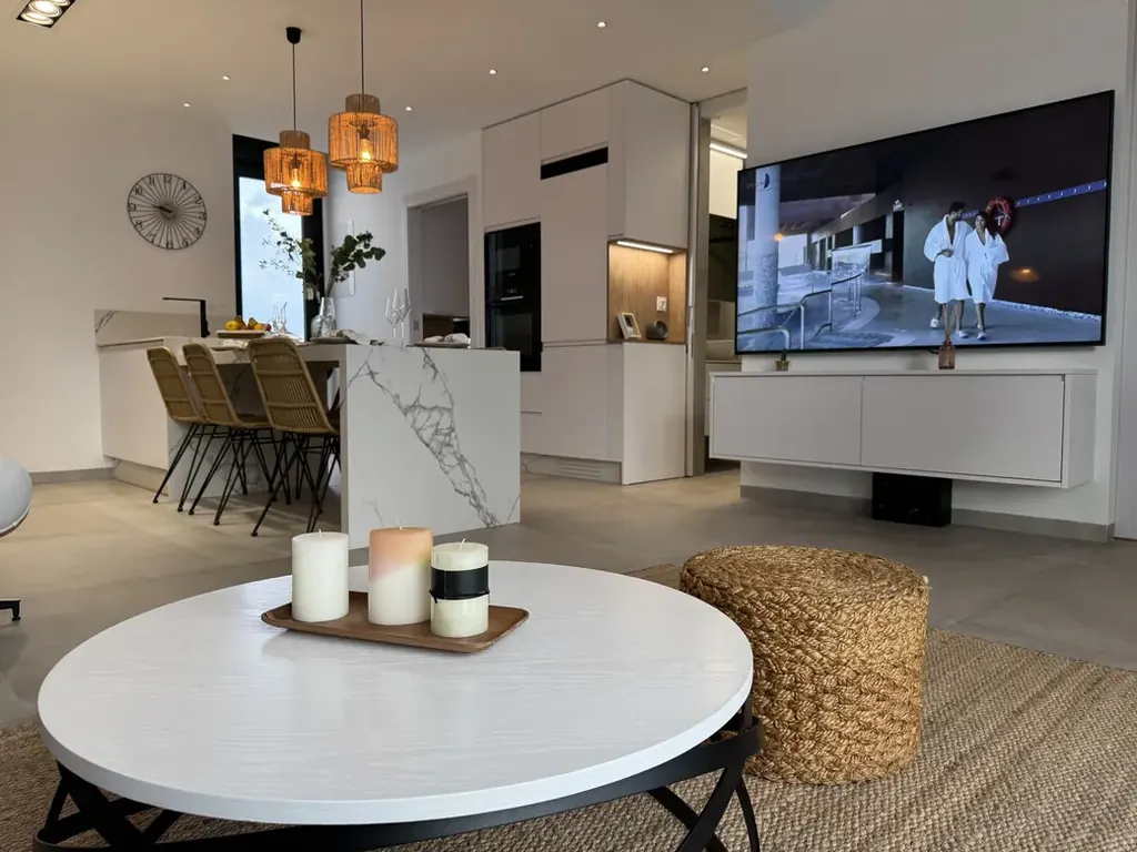 Coin repas lumineux attenant à une cuisine aux finitions marbrées